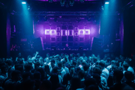 A DJ performing for a packed crowd under blue and purple lights in the main room at Ministry of Sound London.